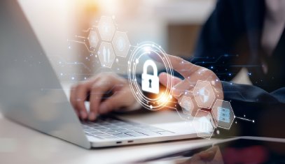 Person using laptop with digital padlock icon representing cybersecurity.