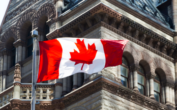 Canadian flag blowing in front of building