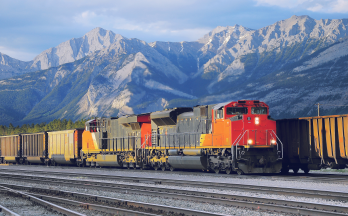 Train on tracks with mountains in the background