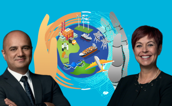 Photo of Elias Rafoul and Chantal Guay in front of a graphic of a stylized globe with one human hand and one robot hand holding it.