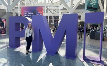 Magdalena Turlejski next to large purple 'PMI' letters at the PMI Global Summit 2024. Magdalena Turlejski next to large purple 'PMI' letters at the PMI Global Summit 2024.