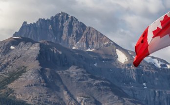 Mise à jour des exigences du CCN relatives à l’accréditation des organismes d’élaboration de normes Drapeau du Canada devant un paysage montagneux.