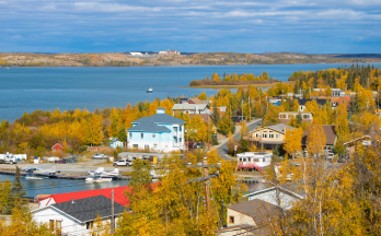 Vue aérienne d’un quartier boisé sur une rivière à Yellowknife, dans les Territoires du Nord Ouest.