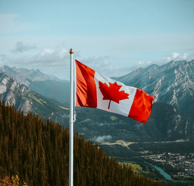 Canadian flag in front of mountains