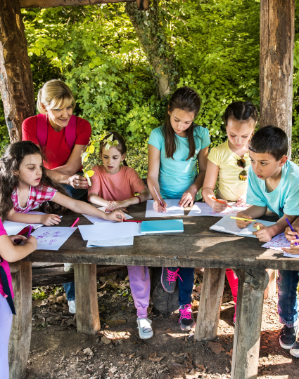 Des enfants colorient à l’extérieur pendant un voyage scolaire