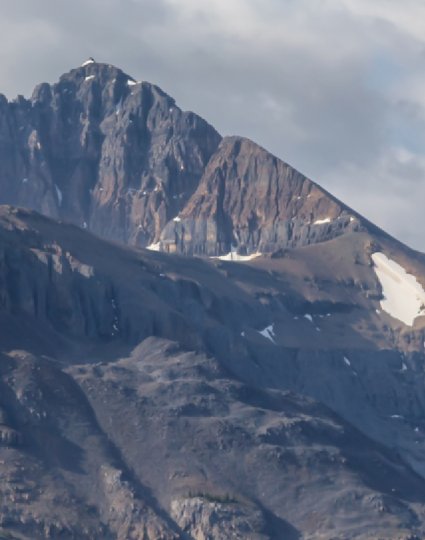 Drapeau du Canada devant un paysage montagneux.