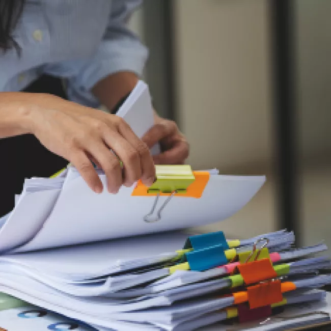 Woman looking through stacks of filed documents