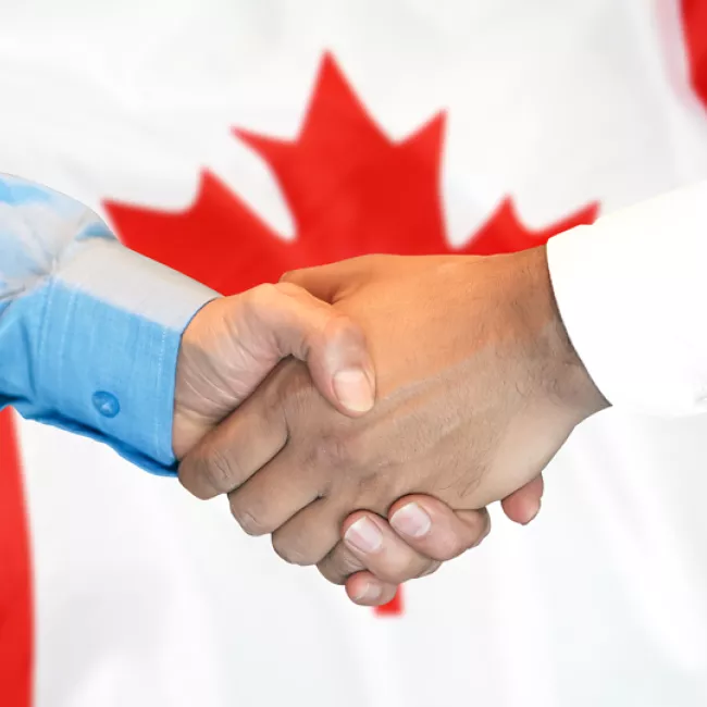 Handshake against Canada flag backdrop