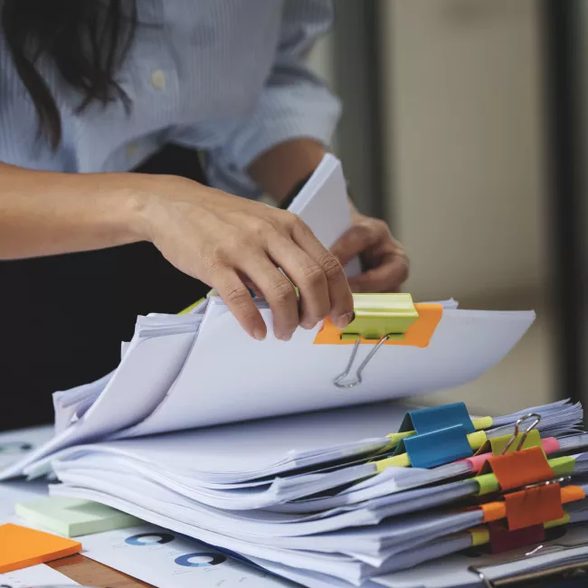 Woman looking through stacks of filed documents