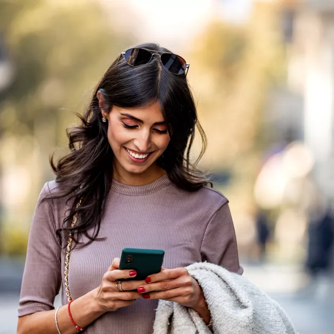 Woman walking and reading on smartphone