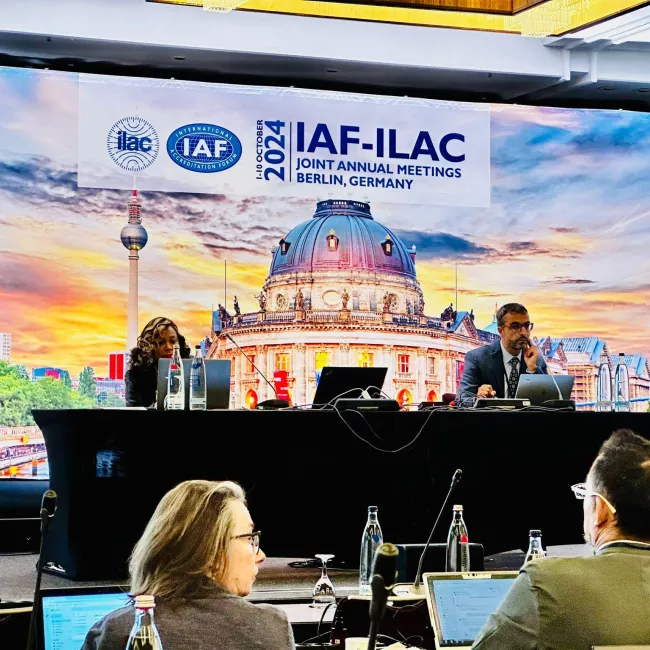 Abdel Kassou co-chairs a digital transformation working group at the IAF-ILAC Joint Annual Meetings in Berlin, Germany, with a backdrop of the Berlin skyline.