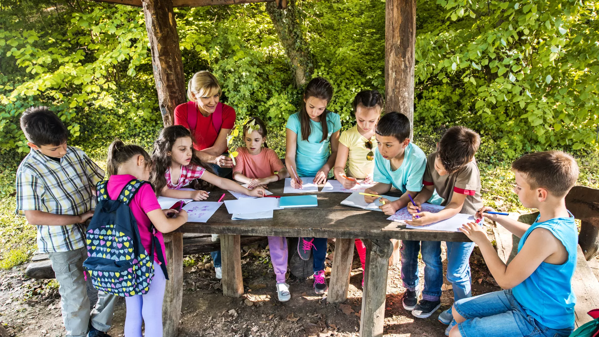 Des enfants colorient à l’extérieur pendant un voyage scolaire