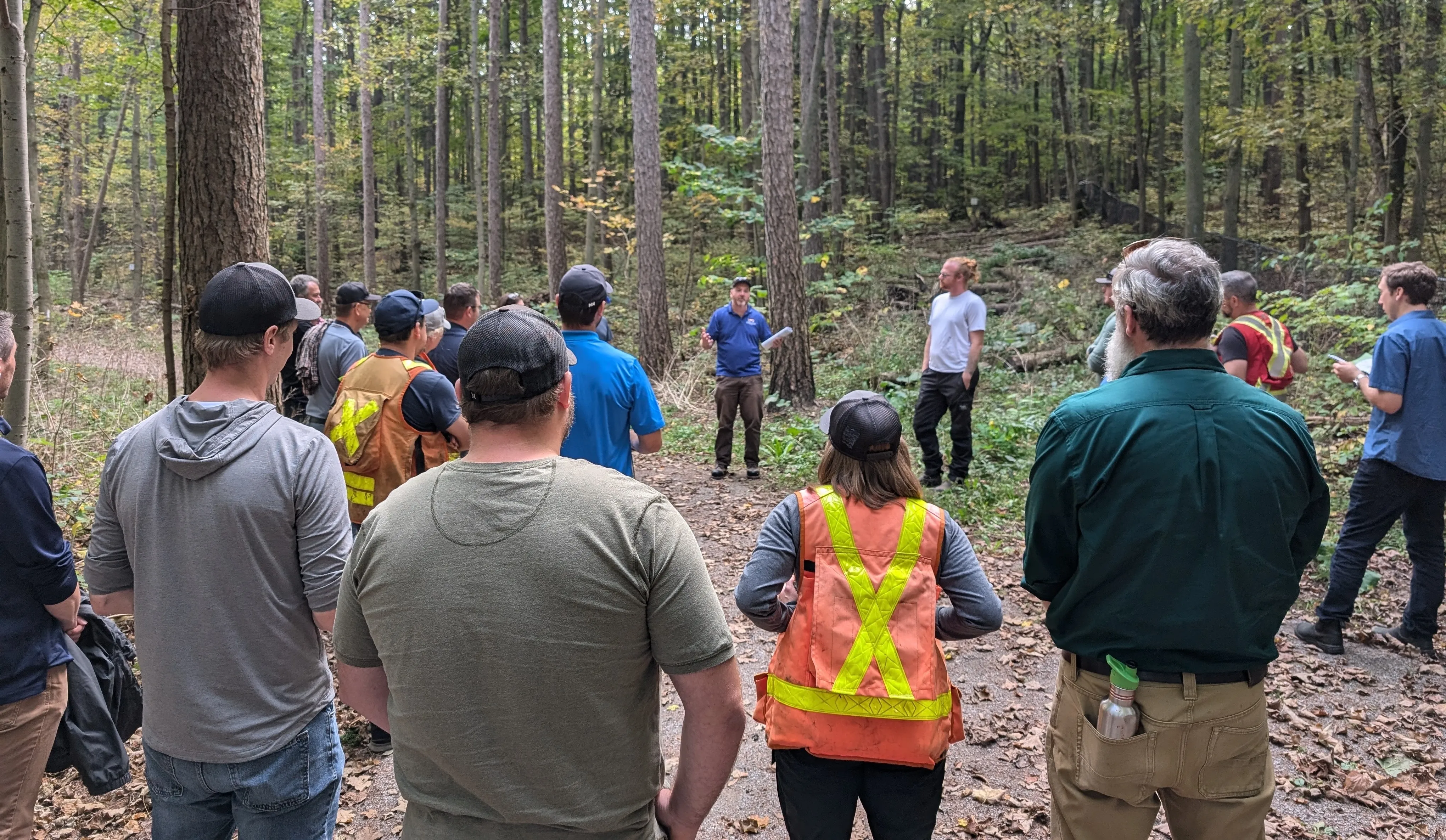 Group of people listening to a speaker during a forest tour.