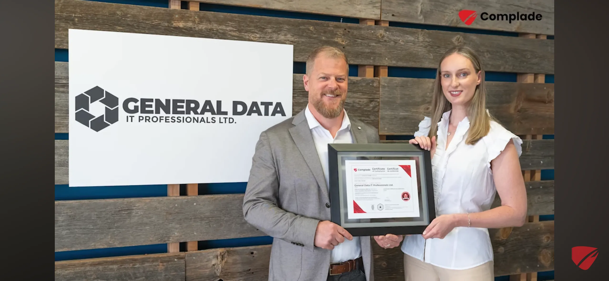 Two people holding a framed certificate in front of a General Data IT Professionals Ltd. sign. Two people holding a framed certificate in front of a General Data IT Professionals Ltd. sign.
