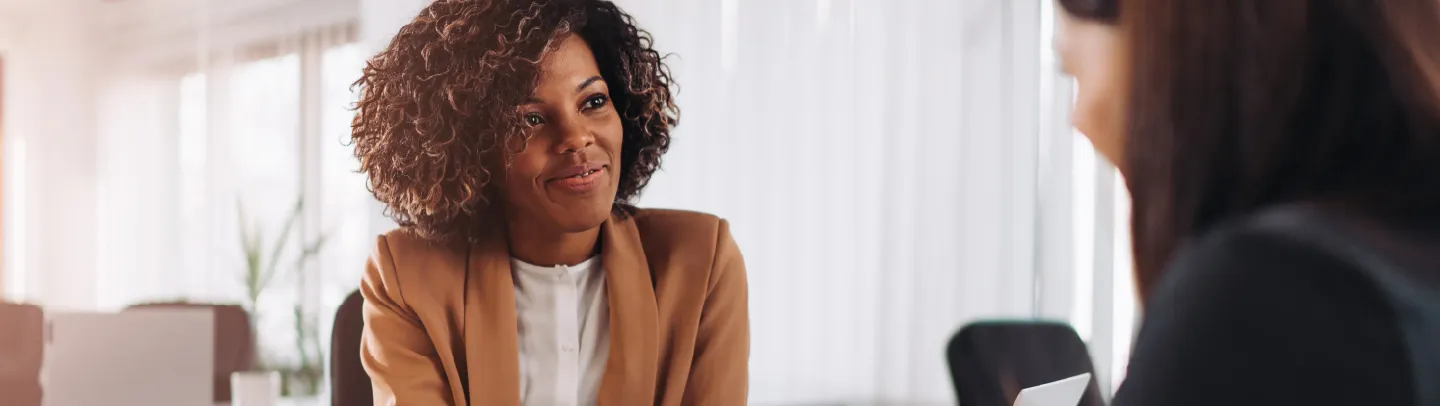 Two women in a professional setting having a conversation.